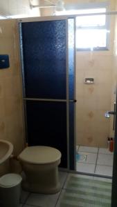 baño con aseo y puerta de ducha de cristal en Capao Canoa - Próximo Mar Centro, en Capão da Canoa