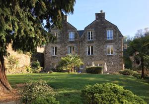 ein altes Steinhaus auf einem grünen Rasen in der Unterkunft Val Rive - Degas Apartment in Dinan