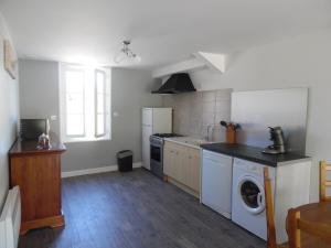 a kitchen with a stove and a washer and dryer at Maison de Vacances Le Ranfort in Sousceyrac