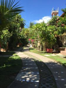einen Pfad in einem Garten mit Palmen und einem Gebäude in der Unterkunft Nhat Quang Bungalow in Mui Ne
