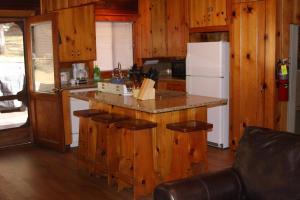 une cuisine avec des armoires en bois et un réfrigérateur blanc dans l'établissement 76 Howards Retreat, à North Wawona