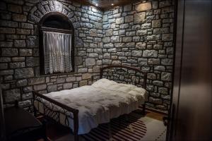 a bedroom with a bed in a stone wall at Stone Mansion Anavryti, ΑΜΑ 20569 in Mystras