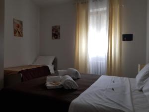 ヴェローナにあるAppartamento Le Campaneのベッドルーム1室(ベッド2台、タオル付)、窓が備わります。