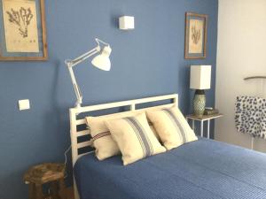 a blue bedroom with a bed and a lamp at Yellow House - Checkinhome in Boliqueime