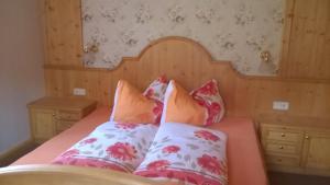 a bed with pink and white pillows on it at Ferienhaus Egger in Innervillgraten +34 photos