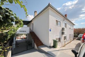 a white house with a staircase in front of it at Apartment Mirela in Zadar