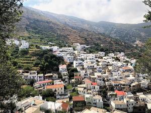 un pueblo en una colina con casas blancas y montañas en Stella's Home in Koronos, en Kóronos