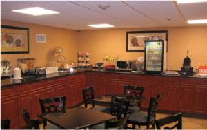 a restaurant with tables and chairs and a counter at Sheridan Hotel in Bronx