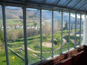 ein Fenster mit Blick auf ein Feld und Häuser in der Unterkunft maison cosy proche de la station de ski du lioran 4 personnes in Thiézac