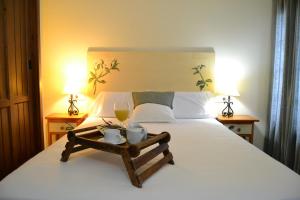 a bed with a white comforter and pillows on it at Hostal Toribio in Galaroza