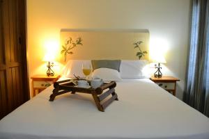 a bed with a white comforter and white pillows at Hostal Toribio in Galaroza