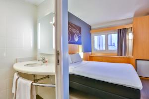 a hotel room with a bed and a mirror at ibis Goiania in Goiânia