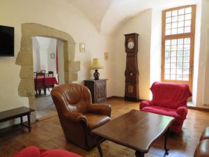 - un salon avec des chaises et une horloge grand-père dans l'établissement le presbytère de Montaigut, à Montégut