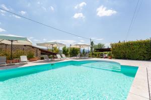 uma piscina com cadeiras e guarda-sóis em Agriturismo Dei Casali em Amelia