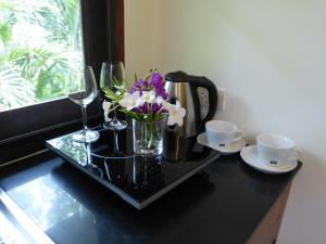 een zwarte tafel met glazen en bloemen erop bij Seagull Villa in Koh Lanta
