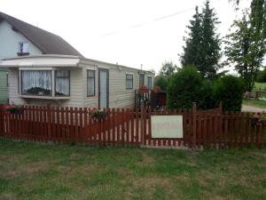 a wooden fence in front of a house at Ubytovani v mobilnim domku in Sobotka