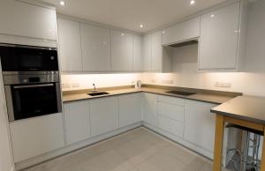 a white kitchen with white cabinets and a sink at Gillespie House in Edinburgh