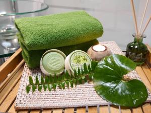 a green spa set with a bottle of soap and a green plant at Casas Serenas in Estreito da Calheta