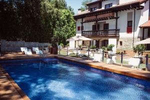 a swimming pool in front of a house at Hotel Cuevas - Adults Only in Santillana del Mar