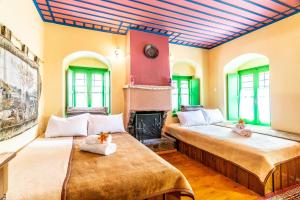 2 camas en una habitación con chimenea en Morfeas Guesthouse, en Papigko 68 fotos más