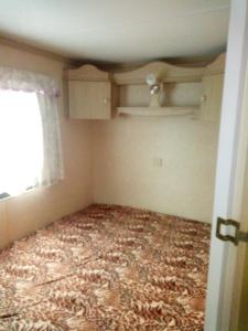ein leeres Zimmer mit einem Teppich auf dem Boden und einem Fenster in der Unterkunft Ubytovani v mobilnim domku in Sobotka