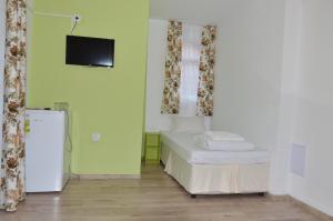 a room with a bed and a tv on the wall at Villa Valentines in Kiten