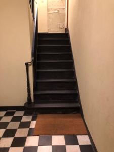 a staircase leading to a door with a checkered floor at Canneto, really downtown in Genoa