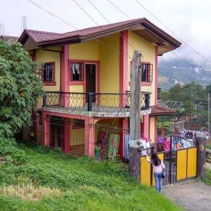 una mujer parada frente a una casa en Cool View Baguio City, en Baguio