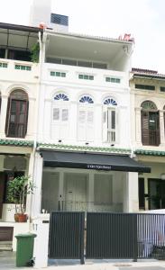 a white building with a black awning in front of it at Comfy Studio 6 by Ong Realty in Singapore