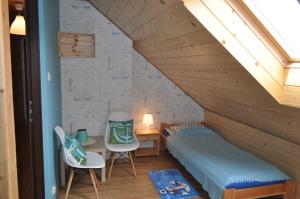 a room with a bed and a desk and chairs at Apartament nad jeziorem in Wilkasy