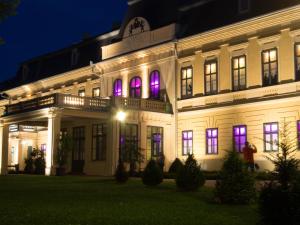 a white building with purple lights in the windows at Feliz apartman in Gyula