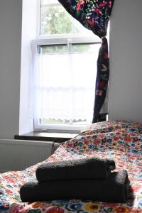 ein Bett in einem Schlafzimmer mit einem Fenster und einer Decke in der Unterkunft Siedlisko Szwałk in Szwalk