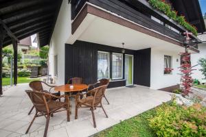 a patio with a wooden table and chairs at apartma mojca in Bohinj