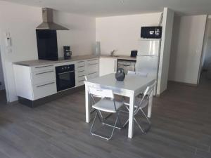 イエールにあるAppartement hyèresのキッチン(白いテーブル、白い冷蔵庫付)