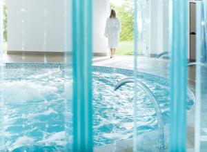 
a woman is standing in a pool of water at Eastwell Manor, Champneys Hotel & Spa in Ashford
