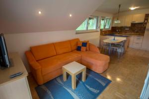 a living room with an orange couch and a table at apartma mojca in Bohinj