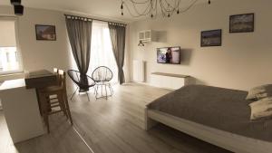 Apartament Termalny Komfort 8.2 في يونيجوو: غرفة نوم بسرير ومكتب وطاولة
