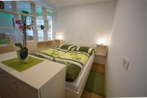 a small bedroom with a bed and a desk at apartma mojca in Bohinj