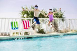 um homem e uma rapariga a saltar para uma piscina em Hotel Blue em Myrtle Beach