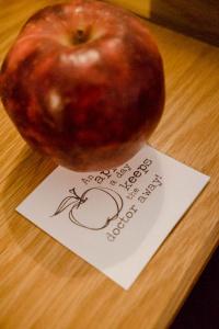 ein Apfel auf einem Tisch neben einem Zettel in der Unterkunft Bodensee Hotel Sternen in Uhldingen-Mühlhofen