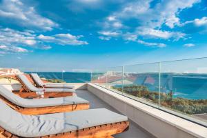 einen Balkon mit Liegestühlen und Meerblick in der Unterkunft Luxury penthouse in Mandre