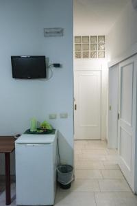 オートラントにあるAurora Sul Mareの冷蔵庫、壁掛けテレビが備わる客室です。