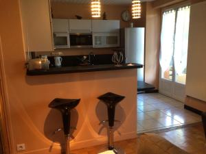 a kitchen with a counter and two stools at T2 gîte de Laurette avec garage et parking privés in Rodez +14 photos