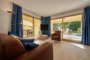 a living room with a couch and a table at Residence Velas Garden Pool Suite in S'Agaro