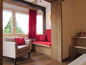 une chambre avec un banc rouge et une fenêtre dans l'établissement Hotel Alpensonne, à Riezlern