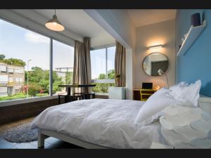 a bedroom with a white bed and a large window at Eshkol Housing Haifa - Moriya Suites Boutique Complex in Haifa