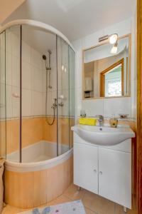 a bathroom with a tub and a sink and a shower at Natali in Omiš