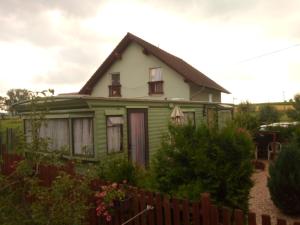 ein grünes und weißes Haus mit einem Zaun in der Unterkunft Ubytovani Fanisek v mobilnim domku v ceskem raji in Sobotka