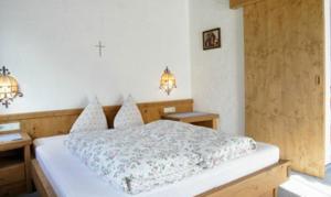 a bedroom with a bed with two tables and two lights at Landsitz im Reitle in Längenfeld