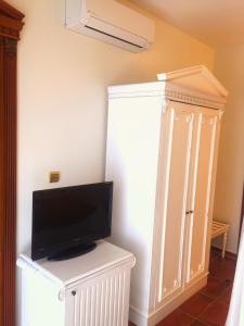 a living room with a tv and a white cabinet at Tas Otel 17 in Behramkale